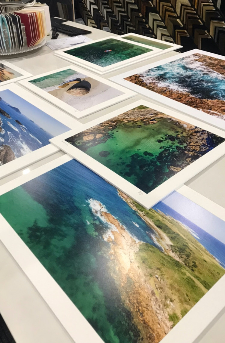 A selection of matted prints laid out ready for framing